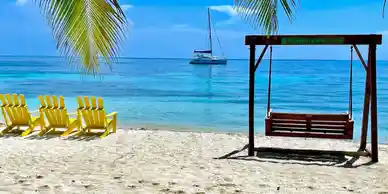 Two yellow chairs on a stunning beach in Belize.
