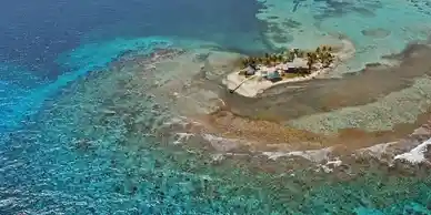 An aerial view of a small island in the ocean, located in Belize.