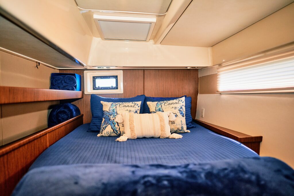 A bed in a boat with a blue comforter.