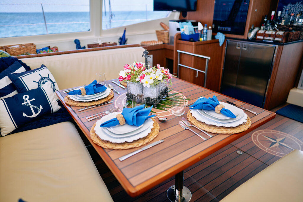A luxury yacht gallery with a table setting and a view of the ocean.
