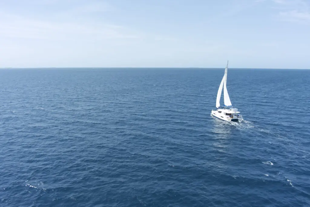 A luxurious white sailboat is sailing in the ocean.