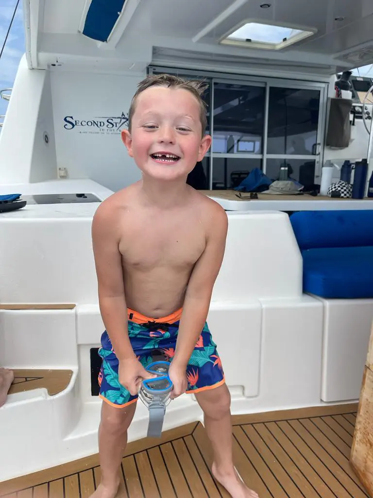 A young boy enjoying a Belize sailing vacation on the deck of a catamaran.